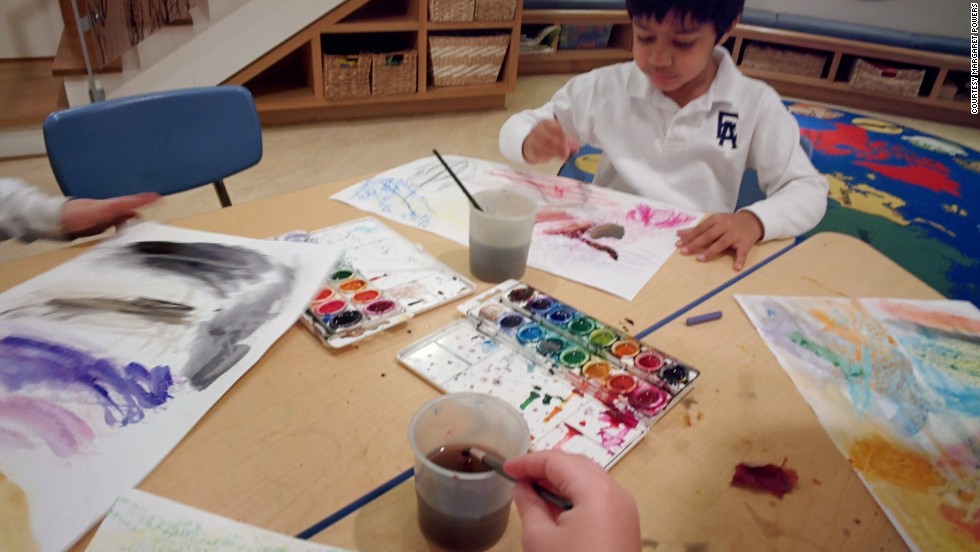 A pre-kindergarten student wears Google Glass while painting with watercolors for a community service project. He documented how crayon and watercolors interact, and the work was eventually sent to be place mats at a local Ronald McDonald House.  