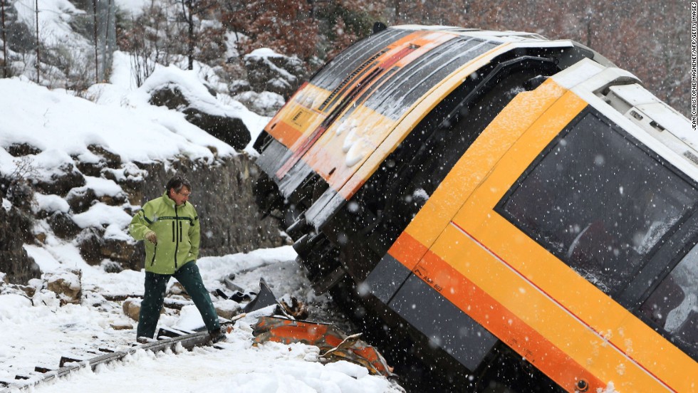 A man inspects the wreckage of the train. 