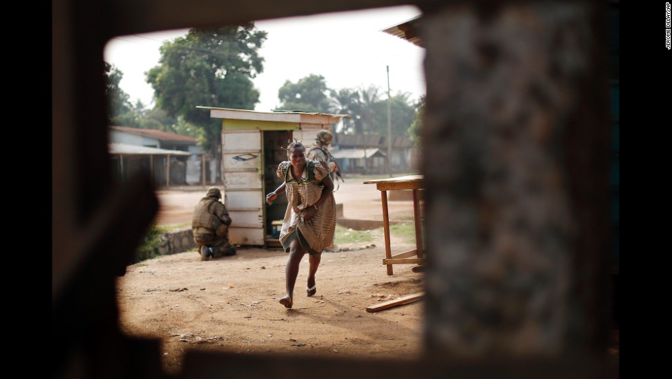 A woman runs for cover as heavy gunfire erupts in the Miskin district of Bangui on Monday, February 3.