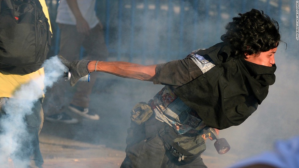 A student protester returns a tear gas canister to riot police on February 15 in Caracas.