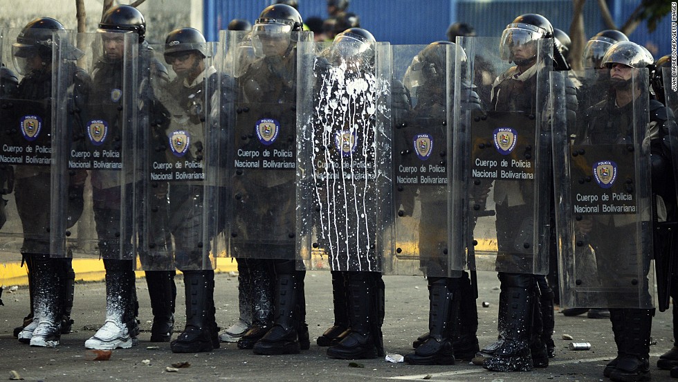 Riot police stand during clashes in Caracas on February 15.