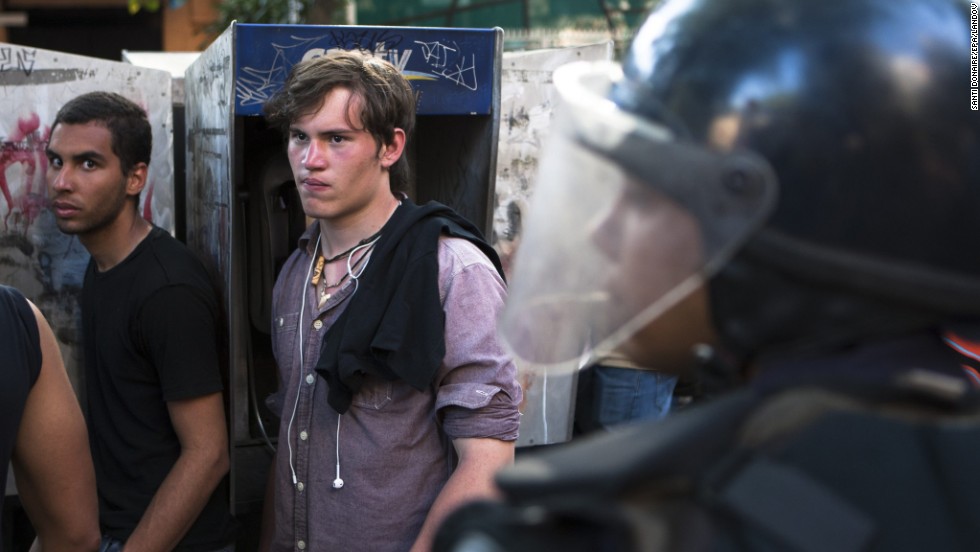 Students stand in front of police February 14 outside the Caracas headquarters for the Organization of American States.