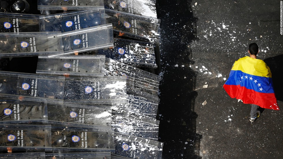 A protester walks past a line of riot police in Caracas on February 12.