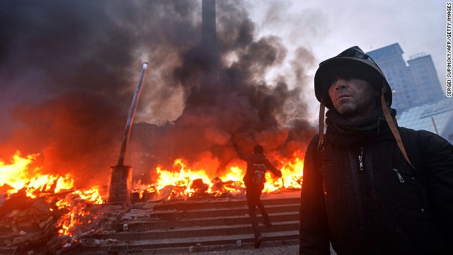 An anti-government protester wearing a helmet stands on Independence Square in Kiev during clashes with the police early on February 19, 2014.