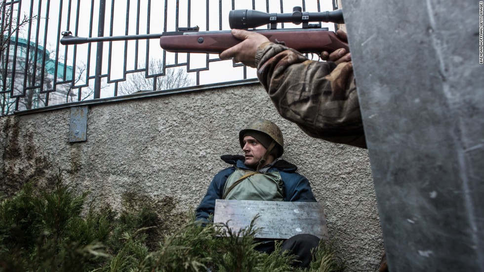 A protester aims a gun in the direction of suspected sniper fire in Kiev on Thursday, February 20. Thousands of demonstrators had packed Independence Square since November when President Viktor Yanukovych reversed a decision on a trade deal with the European Union and instead turned toward Russia.