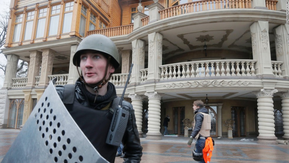 A protester guards the entrance to Yanukovych&#39;s abandoned residence outside Kiev on February 22. 