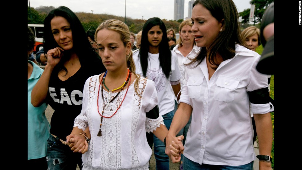 Lilian Tintori de Lopez, the wife of jailed opposition leader Leopoldo Lopez, center, walks hand in hand with actress Norkys Batista, left, and lawmaker Maria Corina Machado as they arrive for a news conference in Caracas on February 24.