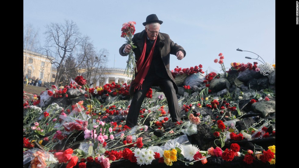A man places flowers at a barricade near Independence Square on February 26.