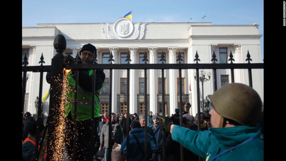 Protesters remove a fence that surrounds Ukraine&#39;s parliament in Kiev on February 26.