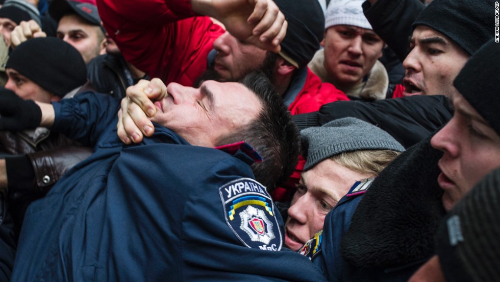 A police officer gets pulled into a crowd of Crimean Tatars in Simferopol on February 26. The Tatars, an ethnic minority group deported during the Stalin era, rallied in support of Ukraine&#39;s interim government.