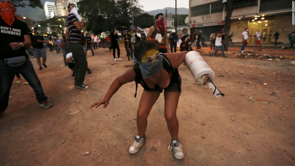 A protester ducks during clashes with police March 3 in Caracas.