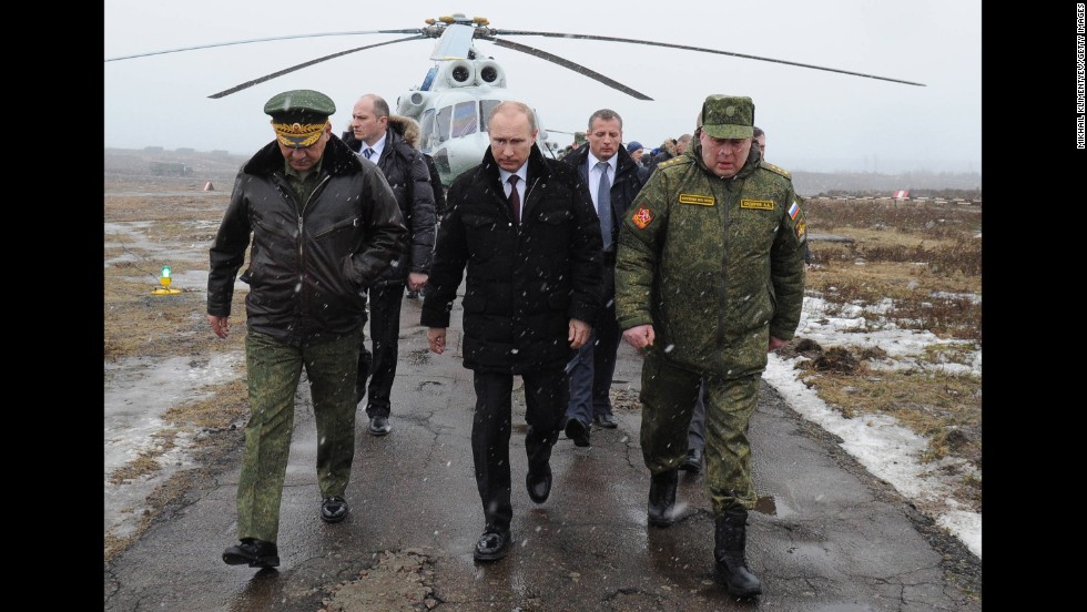 Putin, center, and Defense Minister Sergei Shoigu, left, arrive to watch a March 2014 military exercise at the Kirillovsky firing ground in Russia&#39;s Leningrad region.