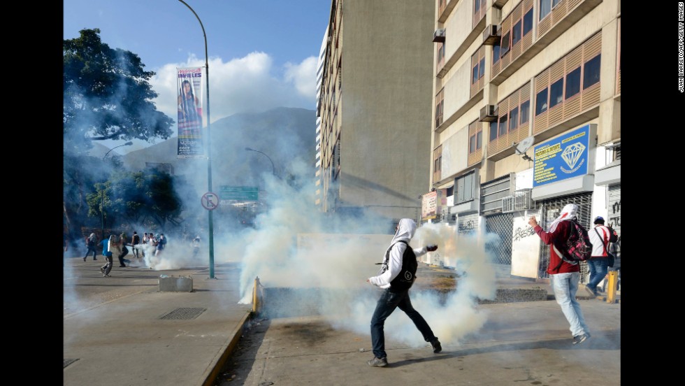 A protester throws a tear gas canister toward National Guard members in Caracas on March 4.