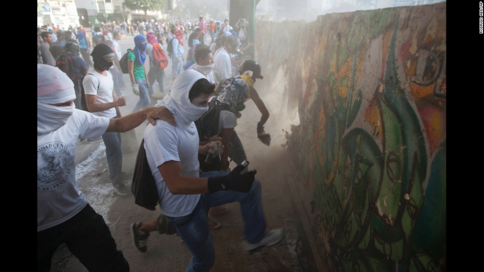 Protesters destroy a wall March 4 to get more rocks to throw at riot police in Caracas.