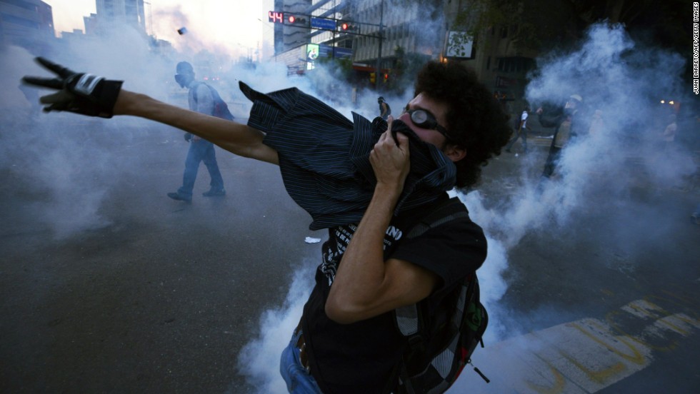 An activist throws tear gas back at riot police during a protest against the government March 5 in Caracas.