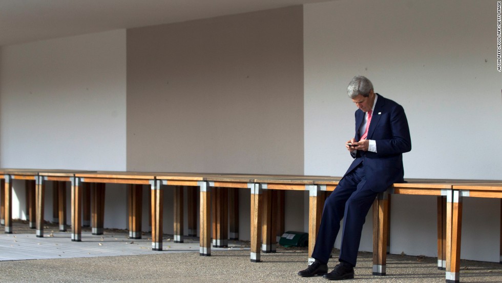 Kerry checks his cell phone in Geneva, Switzerland, prior to a November 2103 meeting with Iran&#39;s foreign minister and the European Union&#39;s high representative for foreign affairs.