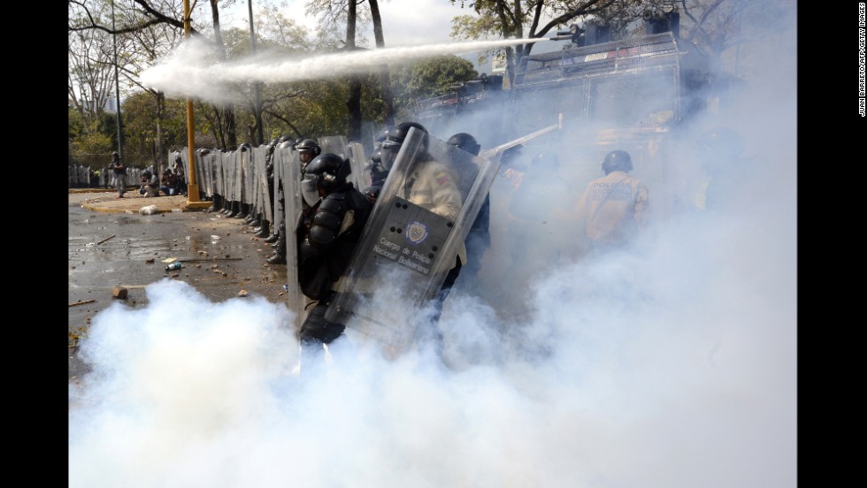 A riot policeman kicks back a tear gas bomb during a protest in Caracas on March 12.