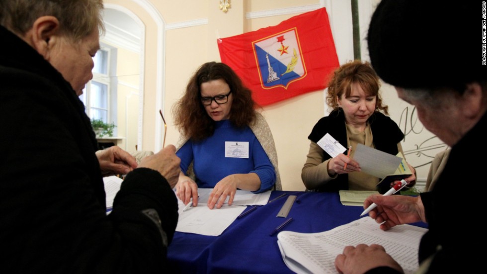 People sign up to receive their ballots from electoral staff at a polling station in Sevastopol.