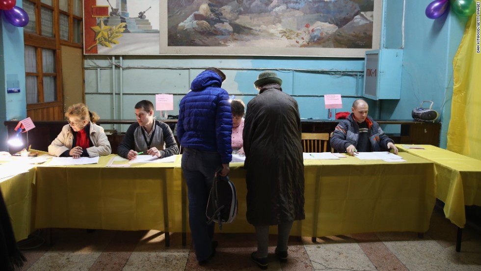 Voters talk to election officials inside a polling station in Simferopol.