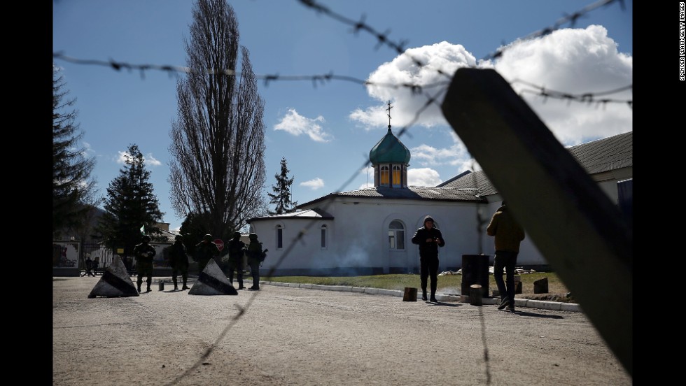 Armed soldiers stand guard outside a Ukrainian military base in Perevalne on March 17.