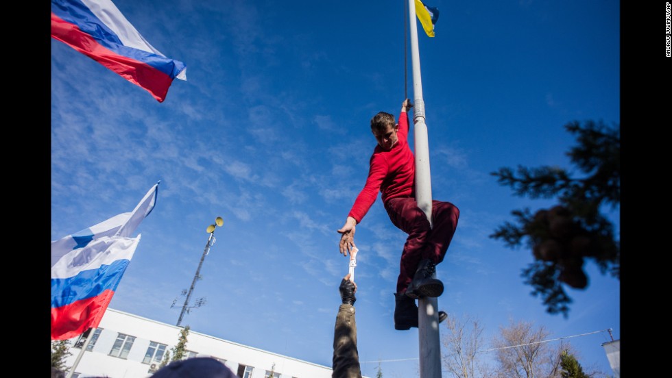 A member of pro-Russian forces takes down a Ukrainian flag at the Ukrainian navy headquarters in Sevastopol on March 19. 
