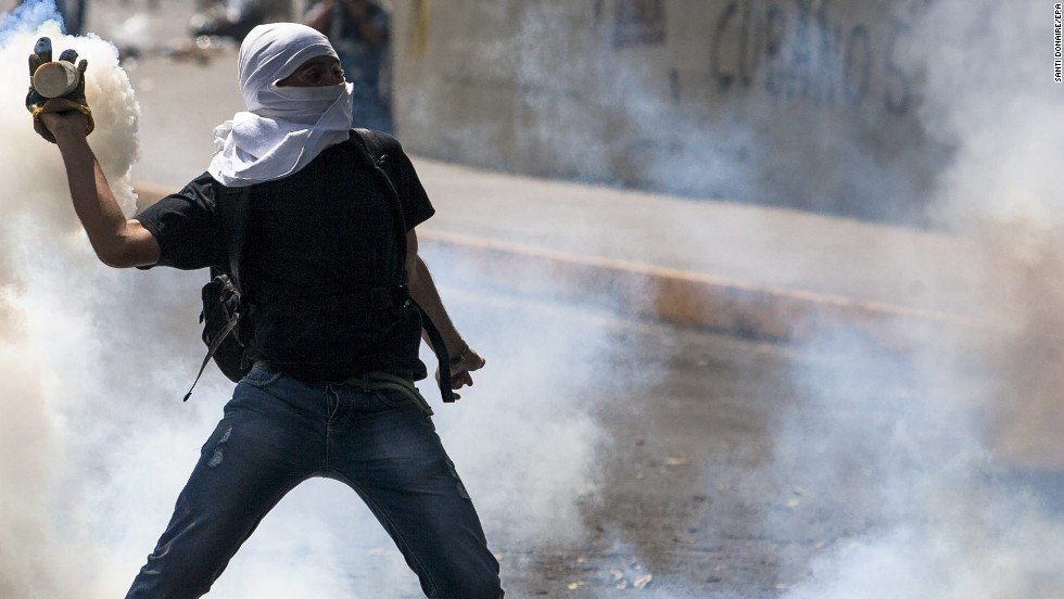A person holds a smoking canister as demonstrators clash with members of the National Police on March 20 in Caracas. 