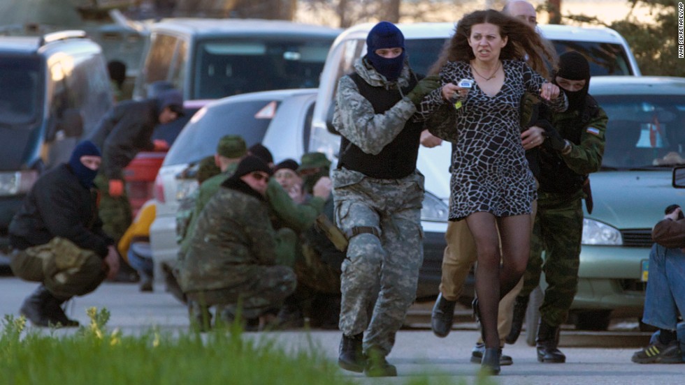 Pro-Russian militia members remove a local resident as Russian troops assault the Belbek air base, outside Sevastopol, on Saturday, March 22. Following its annexation of Crimea, Russian forces have consolidated their control of the region.