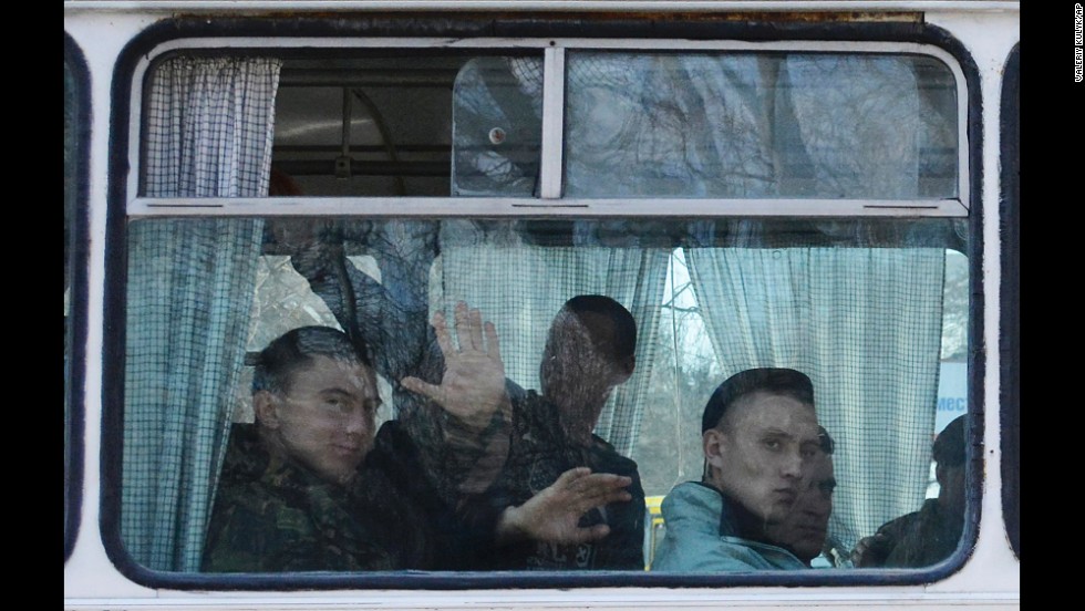 Ukrainian marines wave as they leave a base in Feodosia, Crimea, on Tuesday, March 25. 