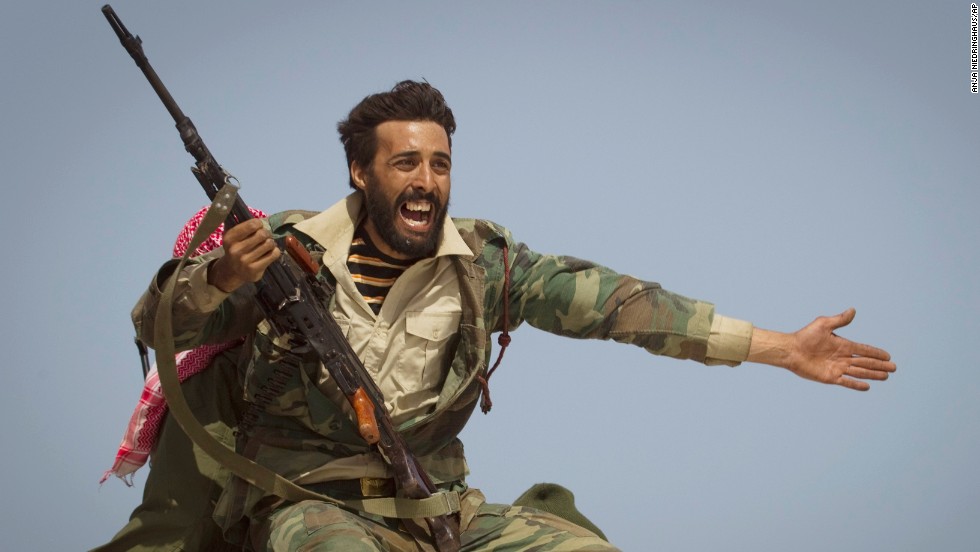 A Libyan rebel urges people to leave as shelling from Moammar Gadhafi&#39;s forces started landing outside of Bin Jawad, Libya, in March 2011.