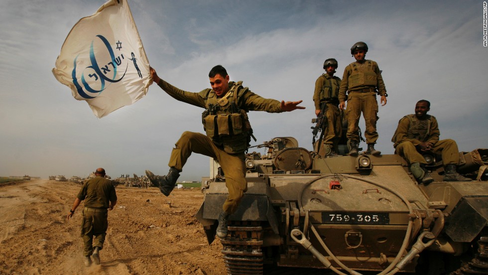 An Israeli soldier jumps off an armored vehicle carrying a flag of Israel&#39;s 60th anniversary as he celebrates with his unit in January 2009.