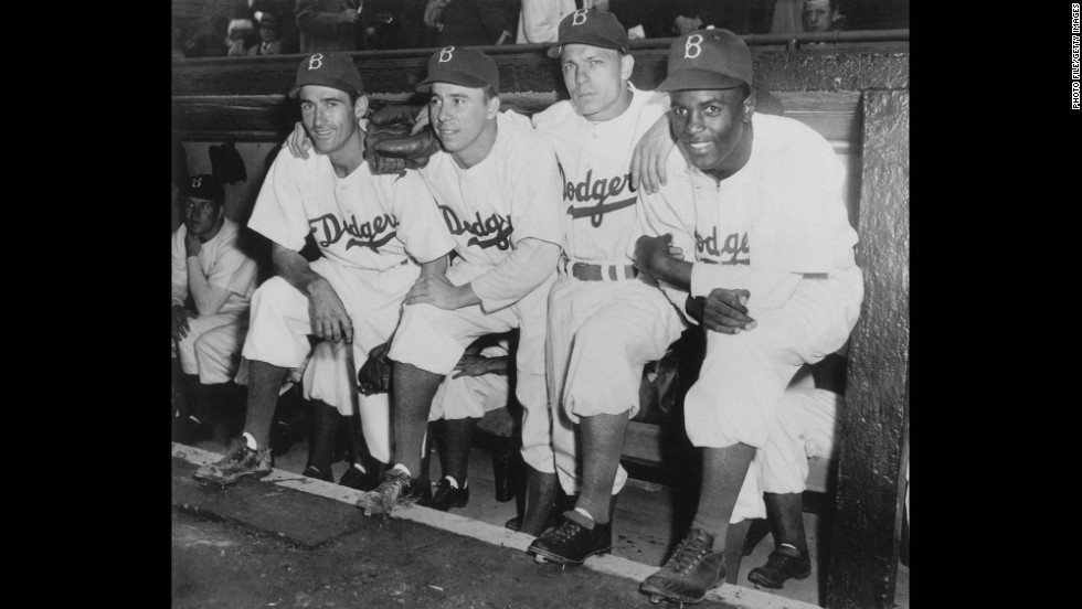 Jackie Robinson, who broke Major League Baseball&#39;s color barrier, poses in the dugout with some of his Brooklyn Dodgers teammates during his first game on April 15, 1947.