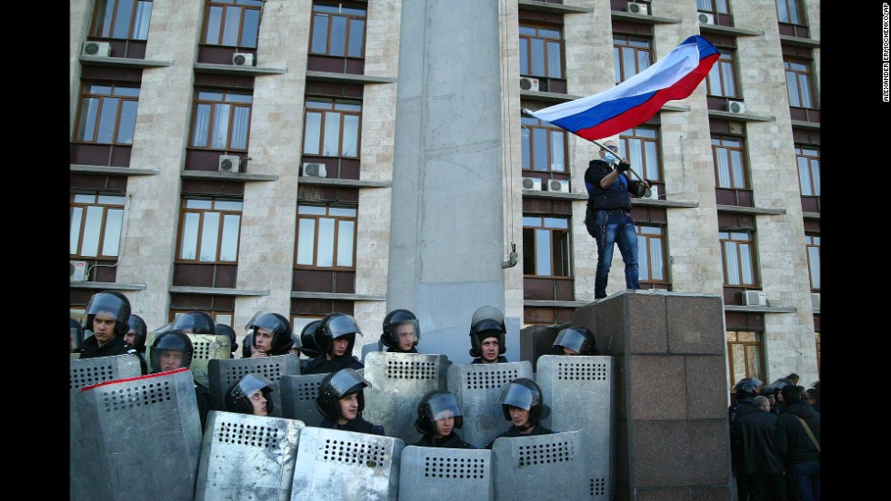 Protesters wave a Russian flag as they storm the regional administration building in Donetsk on Sunday, April 6. Protesters seized state buildings in several east Ukrainian cities, prompting accusations from Kiev that Moscow is trying to &quot;dismember&quot; the country.