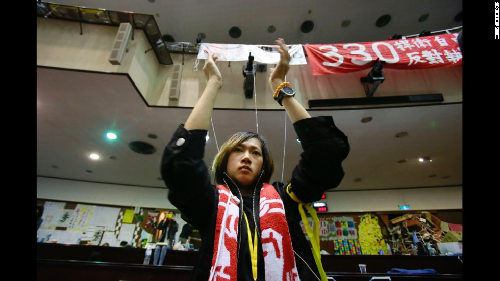 A student protesting a trade pact between Taiwan and China applauds as leaders of the protest speak on the floor of Taiwan&#39;s Legislature on Monday, April 7, in Taipei. Protesters, mostly college students, have been camped out in Taiwan&#39;s Legislature building since March 18. They say the trade deal with China could harm Taiwan&#39;s economy, democratic system and national security. But supporters of the deal have also come out to express themselves.