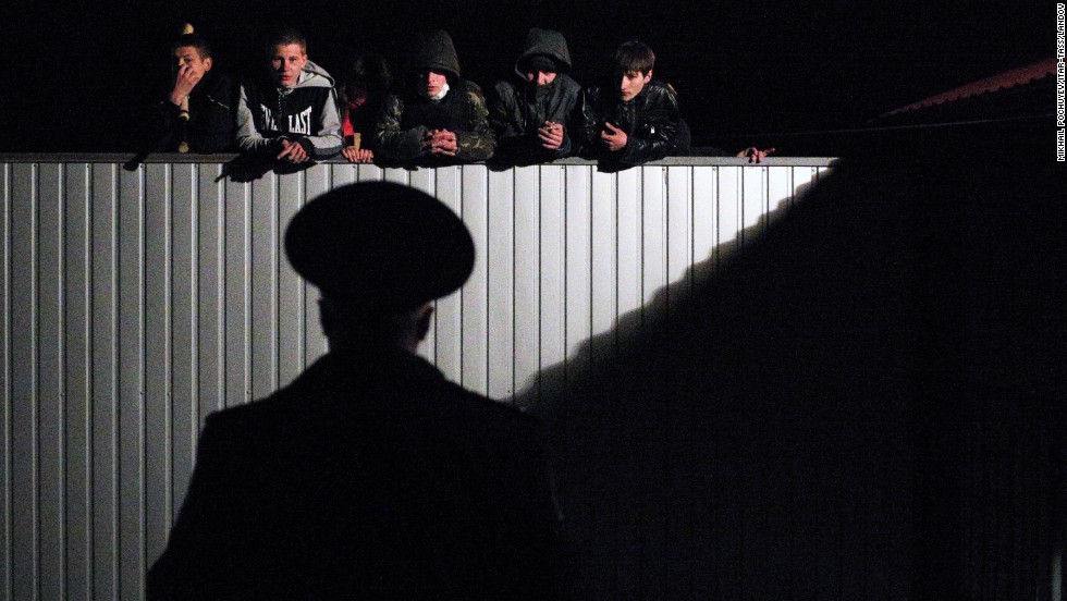 Pro-Russian young men look over the fence of a military recruitment office in Donetsk on Thursday, April 10.