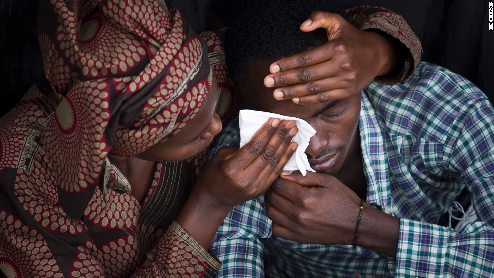 Bizimana Emmanuel, who was born two years before the genocide, is consoled by a woman during a public ceremony at Amahoro stadium in Kigali on April 7 to mark the 20th anniversary of the genocide.