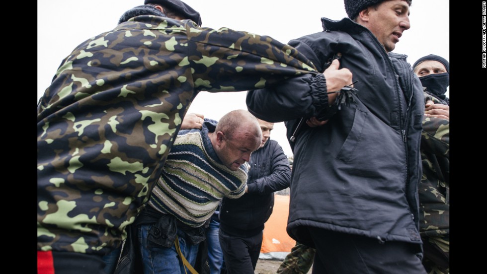 Pro-Russian activists escort a man outside the secret service building in Luhansk on April 13.