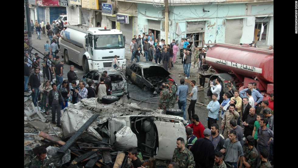 Security and emergency medical personnel work at the site of a car bomb explosion Monday, April 14, in the Ekremah neighborhood of Homs. 