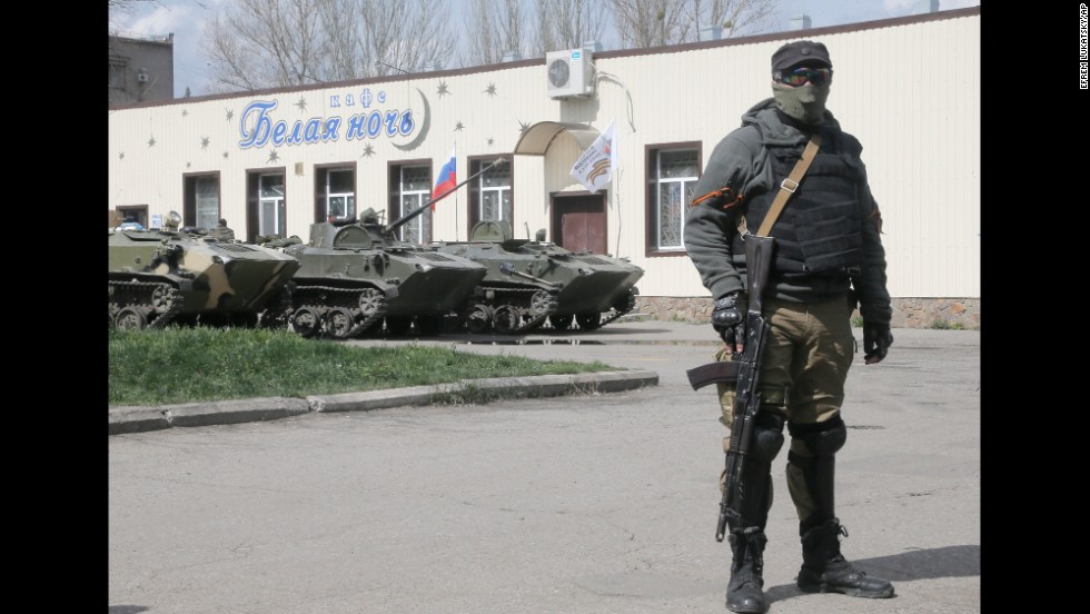A masked pro-Russian gunman guards combat vehicles parked in downtown Slovyansk on April 16.