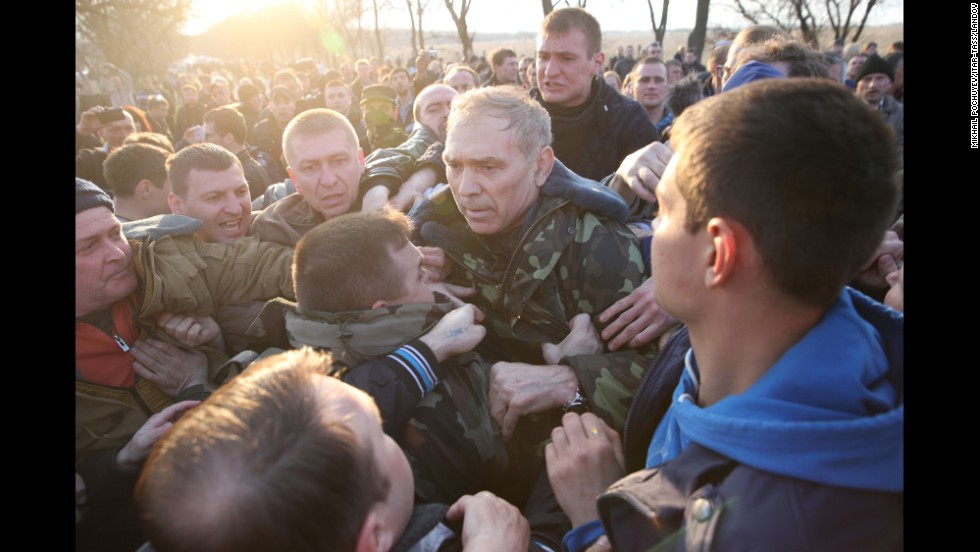 Ukrainian Gen. Vasily Krutov is surrounded by protesters after addressing the crowd outside an airfield in Kramatorsk on Tuesday, April 15.