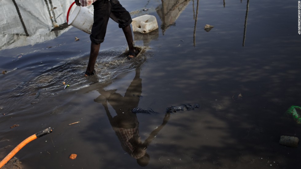 A South Sudanese man walks in a puddle Saturday, March 15, at a camp for internally displaced people.