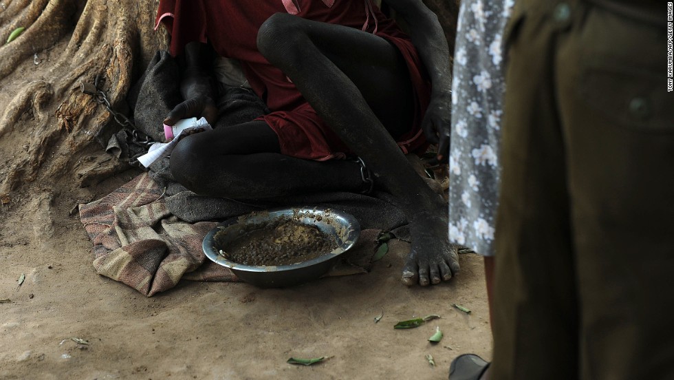 An inmate sits shackled to a tree Wednesday, February 19, in the courtyard of the central prison in Rumbek, South Sudan.