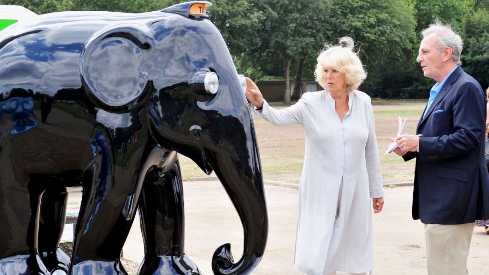 Camilla, Duchess of Cornwall, and her brother, Mark Shand, check out an elephant sculpture designed in the style of a London taxi at the Elephant Parade exhibition at Chelsea Hospital Gardens in London on June 24, 2010.