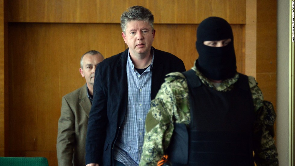 Detained observers from the Organization for Security and Co-operation in Europe arrive to take part in a news conference Sunday, April 27, in Slovyansk. Vyacheslav Ponomarev, the self-declared mayor of Slovyansk, referred to the observers as &quot;prisoners of war.&quot;