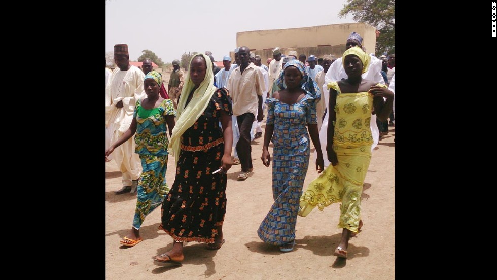 Four female students who were abducted by gunmen and reunited with their families walk in Chibok on Monday, April 21.