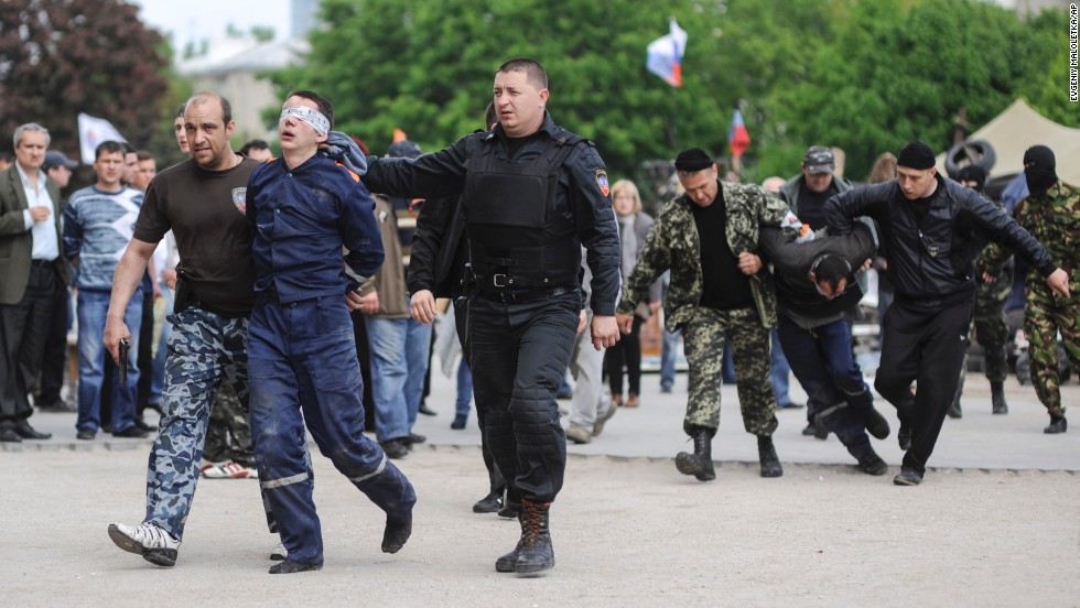 Pro-Russian supporters lead blindfolded men in front of the regional administration building in Donetsk on Monday, May 5.