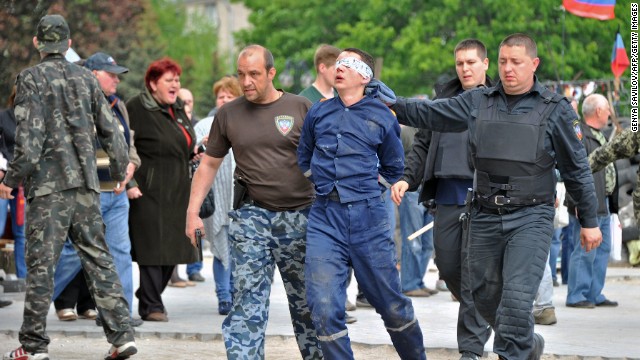 Pro-Russian militants take away a man outside the regional state building they seized in Donetsk on May 5, 2014. 