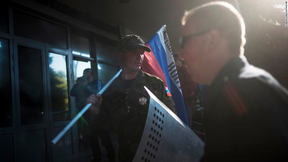 A pro-Russian activist stands with a Russian national flag outside the regional Interior Ministry building in Luhansk on Wednesday, May 7.