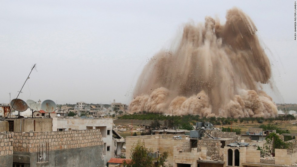 Debris rises in what Free Syrian Army fighters said was an operation to strike a checkpoint and remove government forces in Maarat al-Numan, Syria, on Monday, May 5.