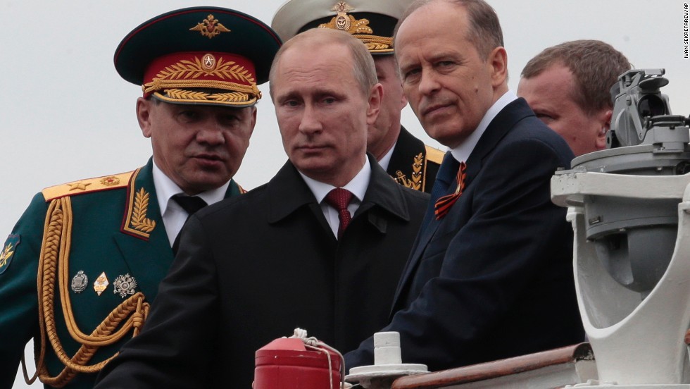 Russian President Vladimir Putin, flanked by Defense Minister Sergei Shoigu, left, and Federal Security Service Chief Alexander Bortnikov, right, arrives at a Victory Day celebration after inspecting battleships in Sevastopol.