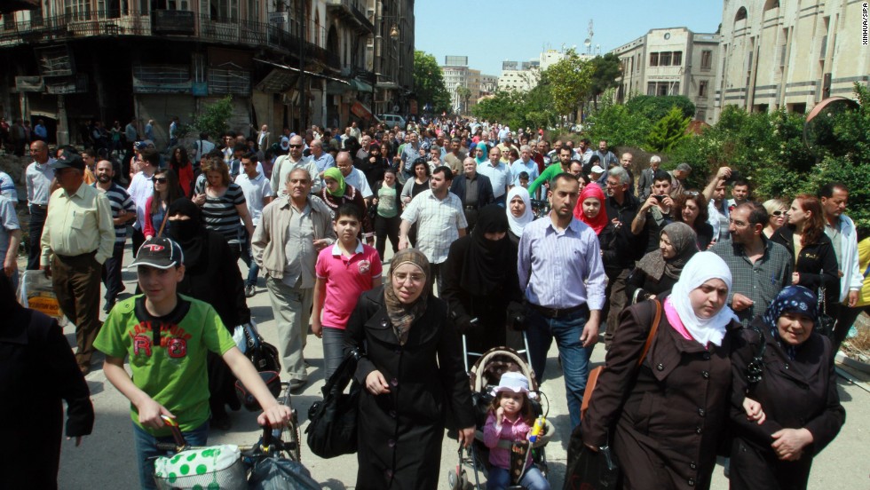 Residents carry their belongings in the al-Hamidieh neighborhood of Homs on May 10.